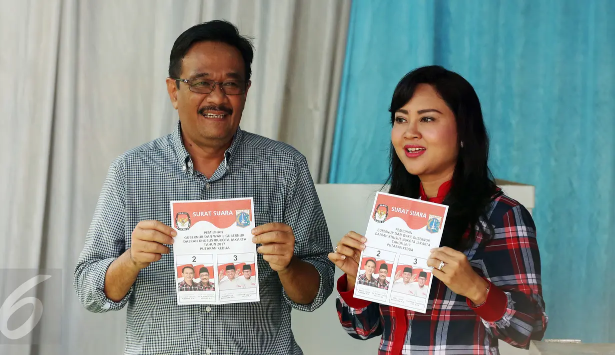 Calon Wakil Gubernur (Cawagub) DKI Jakarta, Djarot Saiful Hidayat, bersama istri, Happy Farida, menunjukan kertas suara saat menggunakan hak pilihya dalam Pilkada Putaran kedua di TPS 8, Kuningan, Jakarta, Rabu (19/4). (Liputan6.com/Johan Tallo)