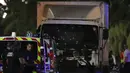 Kondisi sebuah truk putih yang menabrak kerumunan orang yang tengah menyaksikan festival di Nice, Prancis, Kamis (14/7). Hingga kini belum jelas siapa identitas pelaku dan apa motif di balik serangan tersebut. (VALERY HACHE/AFP)