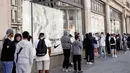 Orang-orang antre untuk memasuki toko Niketown di London, Senin (15/6/2020). Antrean panjang terjadi di luar toko-toko yang berada di sejumlah kota di Inggris saat negara itu melakukan pelonggaran lockdown dan mulai membuka pusat perbelanjaan. (AP/Matt Dunham)