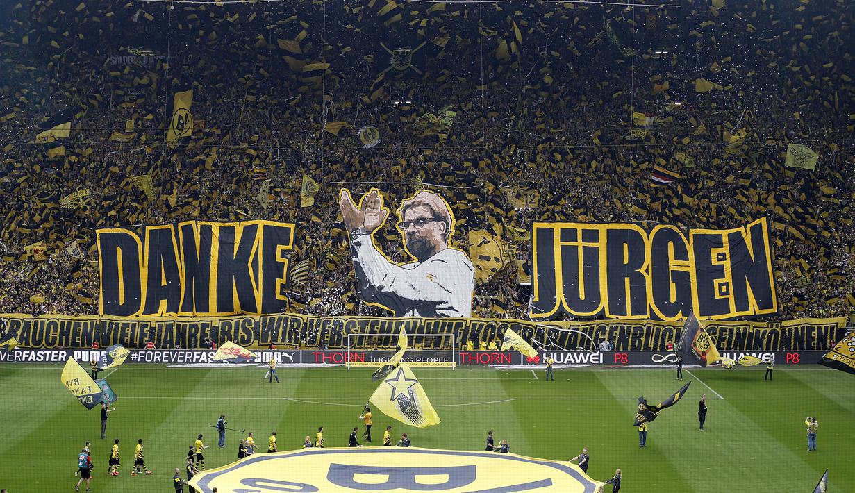 Suporter Borussia Dortmund membentangkan spanduk raksasa berwajah Juergen Klopp dan tulisan 'Danke Jurgen' (terima kasih Jurgen), sebelum laga kontra Werder Bremen di pekan terakhir Bundesliga Jerman, Sabtu (23/5) malam WIB. (AP Photo/Frank Augstein)