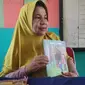 Hasmawati, guru SDN 153 Pekanbaru memperlihatkan buku yang dikarangnya. (Liputan6.com/M Syukur)