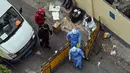 Petugas kesehatan yang mengenakan alat pelindung diri (APD) melintasi pos pemeriksaan saat lockdown akibat virus corona COVID-19 di Distrik Jing'an, Shanghai, China, Sabtu (16/4/2022). (Hector RETAMAL/AFP)