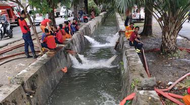 Petugas Damkar Surabaya menyedot genangan air. (Dian Kurniawan/Liputan6.com)