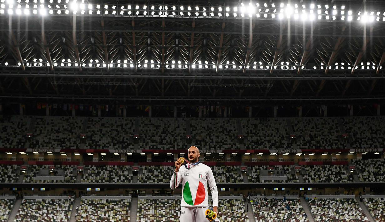 Lamont Marcell Jacobs berpose dengan medali emas usai final 100m putra pada Olimpiade Tokyo 2020 di Olympic Stadium, Tokyo, Senin (2/8/2021). (Foto: AFP/Ina Fassbender)
