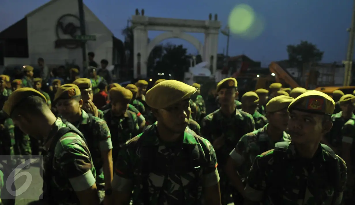 Sejumlah anggota TNI bersiap mengikuti apel sebelum eksekusi penertiban permukiman di Pasar Ikan, Penjaringan, Jakarta, Senin (11/4). Sebanyak 4.218 personel gabungan dikerahkan untuk mengamankan proses penertiban tersebut (Liputan6.com/Gempur M Surya)