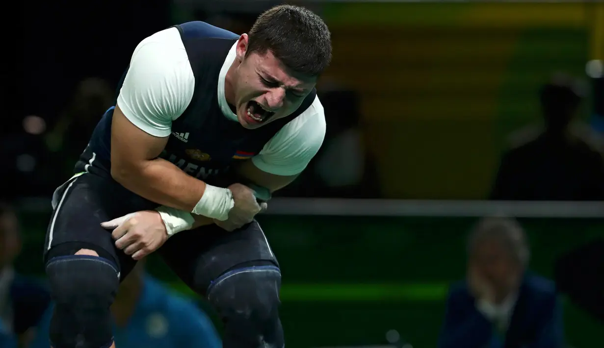 Atlet angkat besi Armenia, Andranik Karapetyan berteriak kesakitan usai mengalami cedera horor ketika tampil pada Olimpiade 2016 di Rio de Janeiro, Rabu (10/8). Siku Karapetyan patah saat hendak mengangkat beban 195 kilogram (REUTERS/Yves Herman)