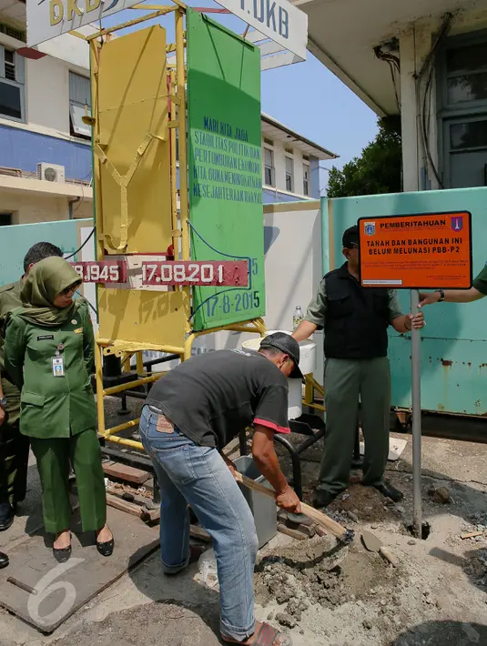 Sejumlah petugas memasang plang di depan PT DKB Dok Perkapalan Galangan I, Tanjung Priok, Jakarta, Senin (23/11). Langkah ini diambil sebagai peringatan bagi para wajib pajak (WP) kelas menengah ke atas mencapai ratusan miliar (Liputan6.com/Faizal Fanani)