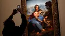 Awak media mengambil gambar "The Virgin and Child with Saint Anne" karya Leonardo Da Vinci di museum Louvre, Paris, Selasa (22/10/2019). Louvre Paris menggelar pameran terbesar  Leonardo da Vinci memperingati 500 tahun wafatnya maestro Italia itu yang dibuka 24 Oktober mendatang (AP/Thibault Camus)