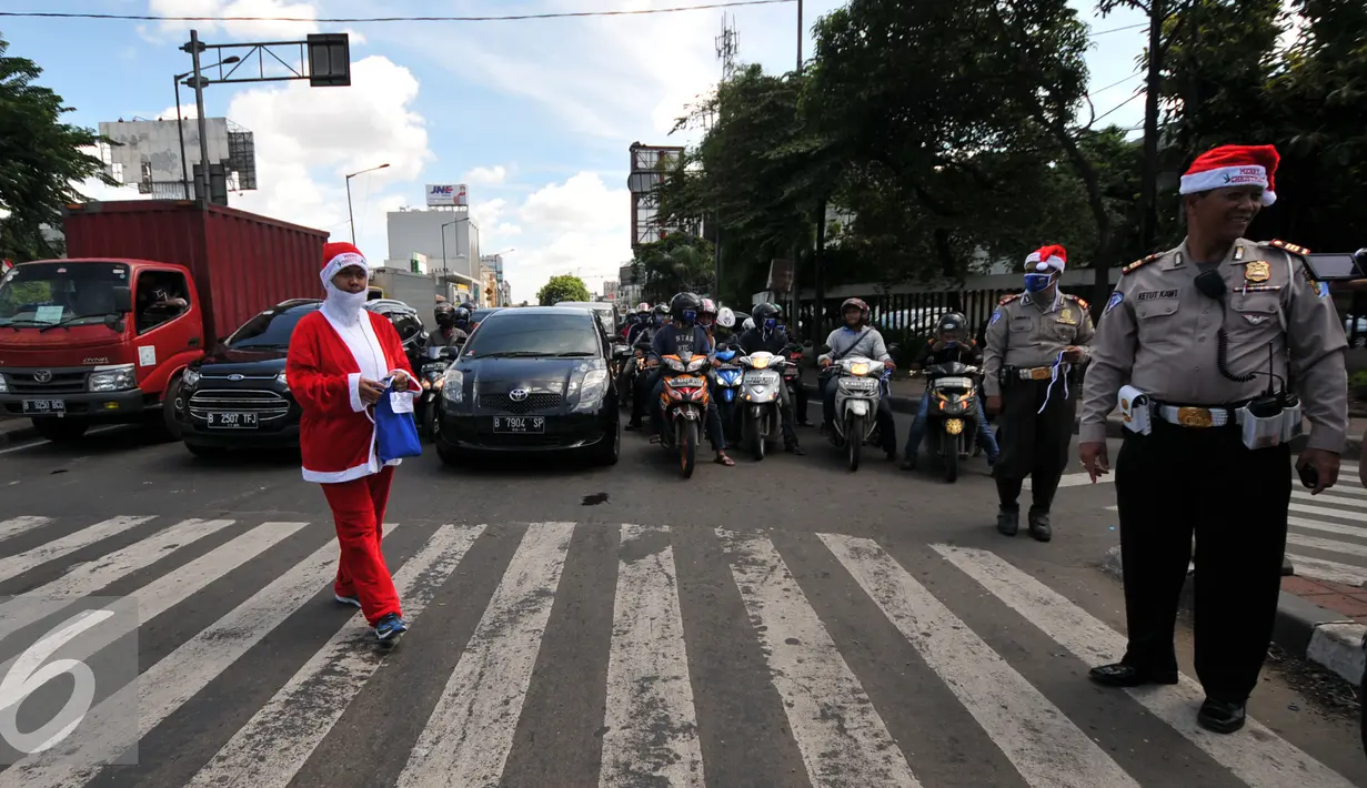 Petugas Kepolisian bersama sinterklas saat membagikan bunga dan masker di jalan kawasan Tomang, Jakarta, Rabu (23/12). Menyambut Hari Natal 2015, anggota Kepolisian Polres Jakarta Barat kenakan topi Sinterklas. (Liputan6.com/Yoppy Renato)