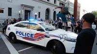 Seorang demonstran merusak mobil polisi saat unjuk rasa di dekat Gedung Putih di Washington (31/5/2020). Demonstran turun ke jalan-jalan di New York City memprotes kematian George Floyd pada (25/5) setelah dijepit di leher oleh seorang petugas kepolisian Minneapolis. (AP Photo/Alex Brandon)