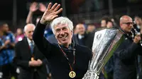 Pelatih Atalanta, Gian Piero Gasperini tersenyum sambil melambaikan tangan saat merayakan gelar juara Liga Europa 2023/2024 setelah mengalahkan Bayer Leverkusen dengan skor 3-0 pada laga final yang berlangsung di Dublin Arena, Irlandia, Kamis (23/05/2024) dini hari WIB. (AFP/Paul Ellis)