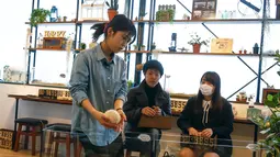 Seorang petugas mengambil landak dari kandangnya di kafe landak, Tokyo, Jepang, 5 April 2016. Terletak di distrik Roppongi, kafe tersebut menghadirkan 20 hingga 30 landak dari berbagai macam jenis. (REUTERS/Thomas Peter)