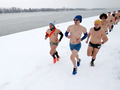 Para pelari ambil bagian dalam Underpants Run di tepi sungai Danube, Serbia pada 26 Januari 2019. Peserta berlari hanya dengan mengenakan pakaian dalam di tengah suhu yang mendekati 0 derajat Celcius. (AP/Darko Vojinovic)
