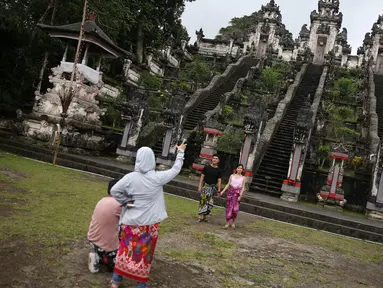 Wisatawan berfoto di sekitar Pelataran Agung Pura Lempuyang, Karangasem, Bali, Kamis (7/12). Erupsi Gunung Agung menyebabkan sejumlah destinasi wisata di kawasan Bali Timur mengalami penurunan jumlah wisatawan. (Liputan6.com/Immanuel Antonius)