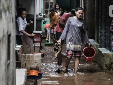 Warga membersihkan lumpur dan sampah saat banjir di permukiman Kebon Pala, Jatinegara, Jakarta, Minggu (25/10/2020). Hampir 12 jam banjir kiriman dari Bogor itu masih merendam permukiman warga di RT 11 RW 05 Kebon Pala dengan ketinggian mencapai pinggang orang dewasa.  (merdeka.com/Iqbal Nugroho)