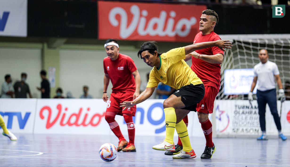 Pemain Golden Arrow, Budi Sudarsono (tengah) berebut bola dengan pemain Red Rocket, Cristian Gonzales pada laga futsal Turnamen Olahraga Indonesia (TOSI) Season 3 yang berlangsung di Indomilk Arena, Tangerang, Sabtu (12/10/2024). (Bola.com/Bagaskara Lazuardi)