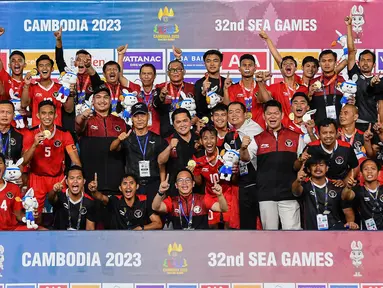 Ketua Umum PSSI Erick Thohir (tengah), Menpora Dito Ariotedjo, Ketua NOC Indonesia Raja Sapta Oktohari, CdM Lexyndo Hakim, staf pelatih, ofisial, dan pemain Timnas Indonesia U-22 berpose memegang medali emas SEA Games 2023 setelah mengalahkan Thailand dengan skor 5-2 pada laga final yang berlangsung di Olympic Stadium, Phnom Penh, Kamboja, Selasa (16/05/2023). (AFP/Nhac Nguyen)