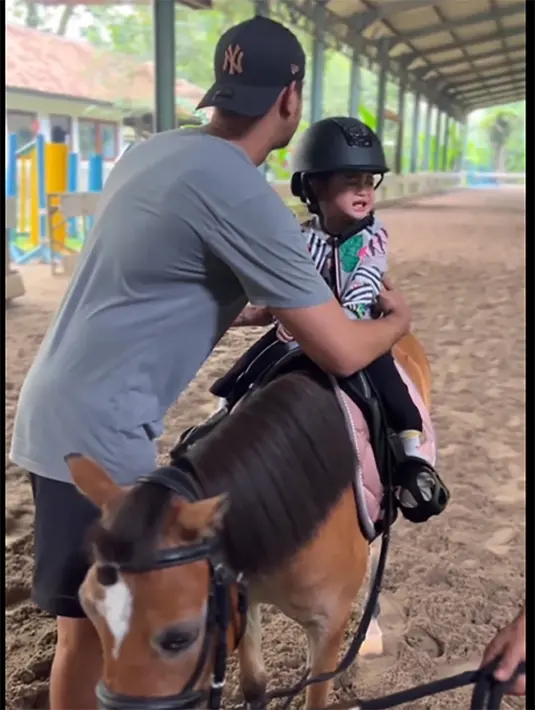 Ekspresi sedih baby Guzel saat dibujuk dan akan diangkat ayahnya turun dari kuda. "Duuuh Xpresi muka guzel lucu bgt lirikan matany,pake ketawa lagi bimes bgt bikin gemeeeess,,, setuju sih bayi tercantik," tulis evyta238. "MasyaAllah guzeelll gemes bget," tulis tinsyafaaaa. [Instagram/marginw]