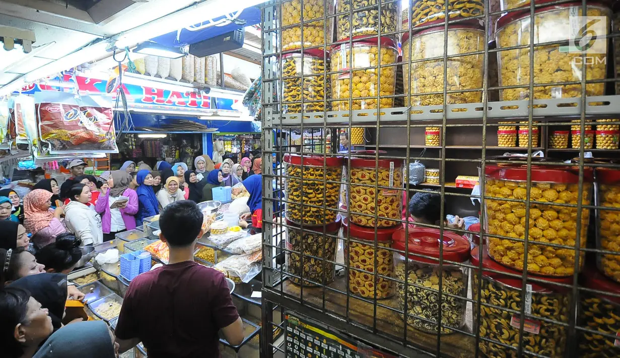 Sejumlah pembeli mengantre saat membeli kue kering di Pasar Jatinegara, Jakarta, Senin (27/5/2019). Jelang Idul Fitri 2019, banyak warga berburu makanan ringan seperti kue kering untuk jamuan di hari raya. (Liputan6.com/Angga Yuniar)