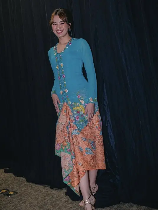 Mawar Eva tampil memesona mengenakan kebaya encim warna biru berbordir bunga dari Fadlan Indonesia. Dipadukan kain corak batik warna orange. [@mawar_eva]