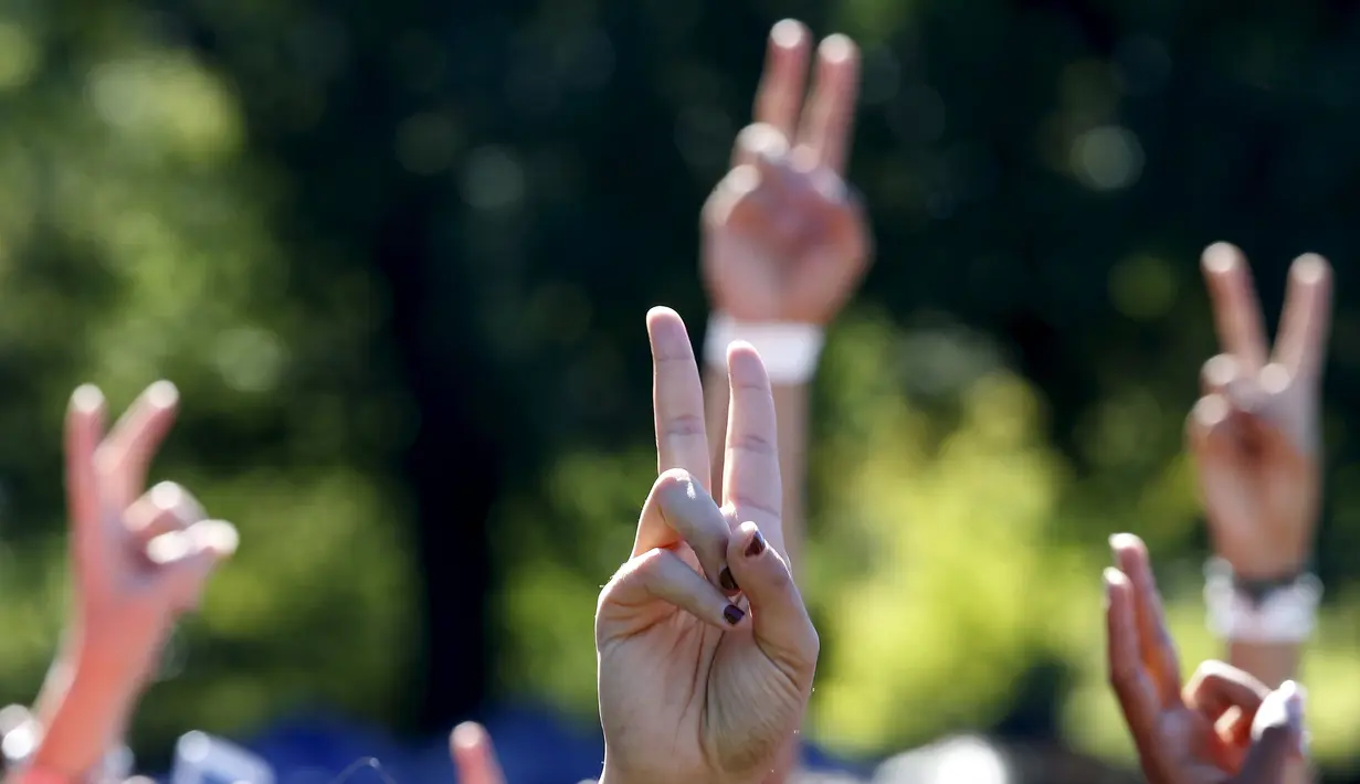 Sejumlah orang menunjukkan tanda perdamaian saat berkumpul untuk membentuk simbol perdamaian raksasa di New York Central Park , Selasa (6/10). Kegiatan yang diprakarsai janda Lennon, Yoko Ono itu menandai ulang tahun John Lennon ke-75.(REUTERS/Mike Segar)