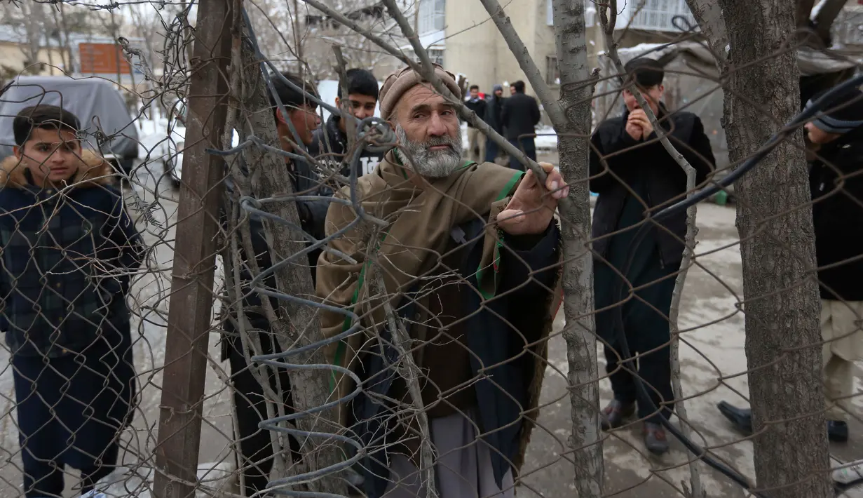 Sejumlah orang mengawasi lokasi ledakan bom yang terjadi di kompleks Mahkamah Agung (MA) di ibu kota Afghanistan, Kabul, Selasa (7/1). Pelaku bom bunuh diri tampaknya meledakkan diri di area pemeriksaan sekuriti MA. (AP Photo/Rahmat Gul)