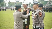Wakil Kepala Polda Riau Brigjen Kasihan Rahmadi memasang pita kepada petugas yang melaksanakan Operasi Patuh 2023. (Liputan6.com/M Syukur)