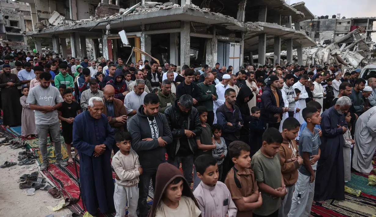 Warga Palestina melaksanakan salat menandai dimulainya Idul Adha, Hari Raya Kurban, di jalan yang rusak parah di Khan Yunis, Jalur Gaza Selatan, pada Rabu 27 Mei 2026. (BASHAR TALEB/AFP)