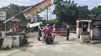 Palang pintu manual perlintasan KRL Rawa Geni dibuka kembali warga Kecamatan Cipayung, Kota Depok. (Liputan6.com/Dicky Agung Prihanto)