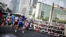 Warga menyaksikan pertandingan tinju amatir yang berlangsung saat Car Free Day di kawasan Bundaran HI, Jakarta, Minggu (29/4). Pertandingan tersebut untuk mendukung penyelenggaraan Asian Games 2018. (Liputan6.com/Faizal Fanani)