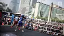 Warga menyaksikan pertandingan tinju amatir yang berlangsung saat Car Free Day di kawasan Bundaran HI, Jakarta, Minggu (29/4). Pertandingan tersebut untuk mendukung penyelenggaraan Asian Games 2018. (Liputan6.com/Faizal Fanani)