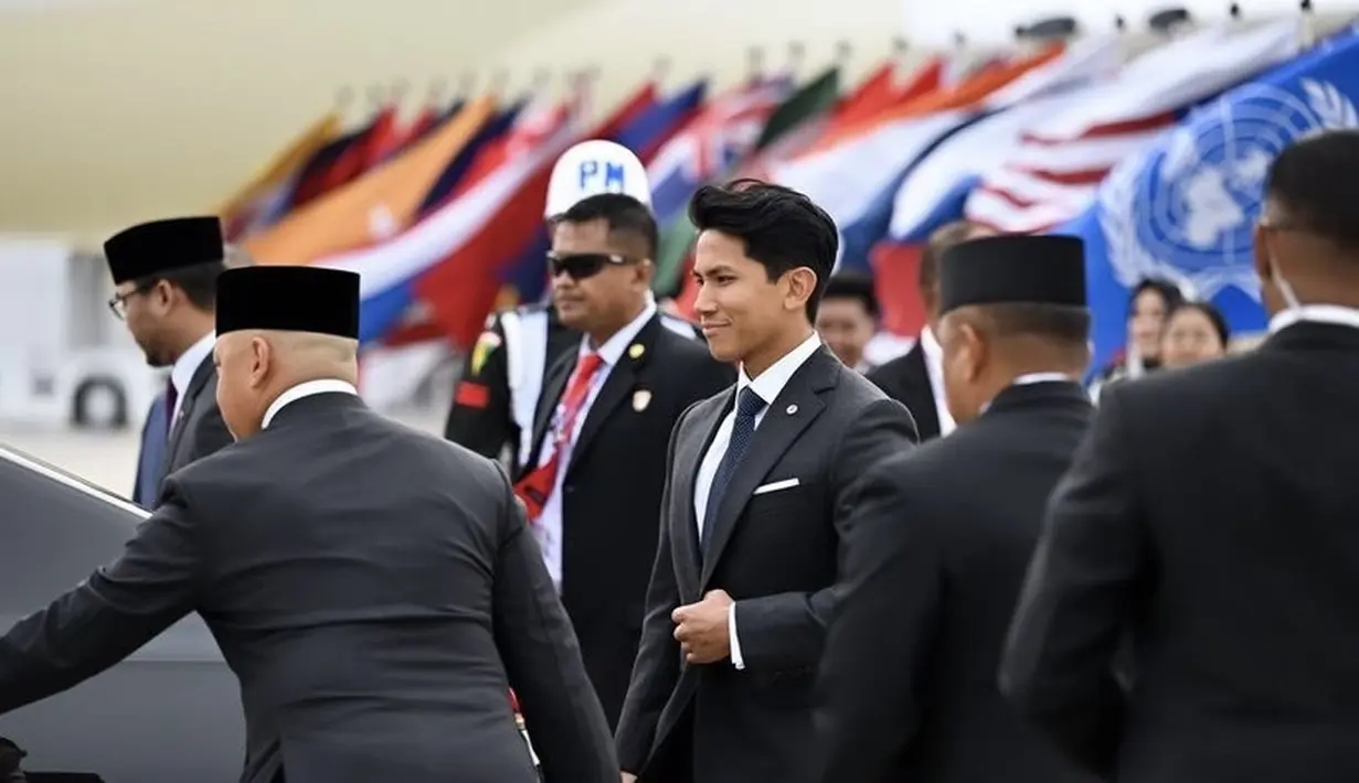 Ia memadukannya dengan inner kemeja putih, lengkap dengan dasi birunya. Lengkap dengan bros lambang kebangsaannya. [@tmski]