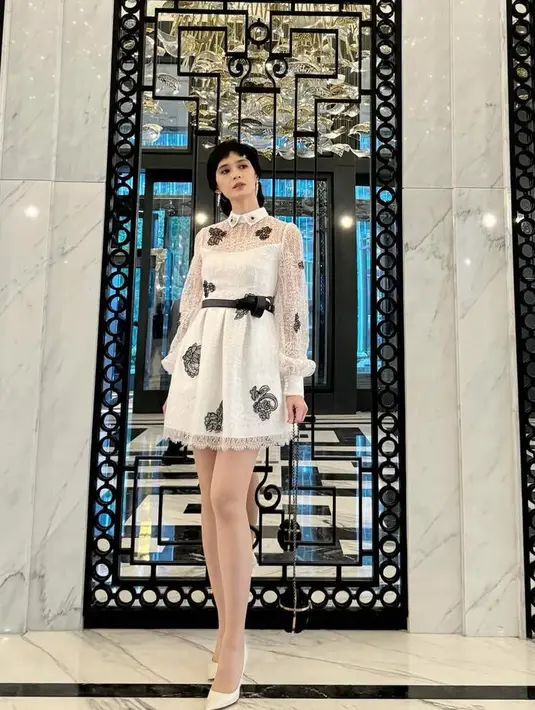 Renata tampil feminim mengenakan mini dress putih dari desainer Sebastian Red. Mini dress lengan panjang sheer memiliki aksen kerah dan bordiran bunga, dengan belt hitam.[@renata711]