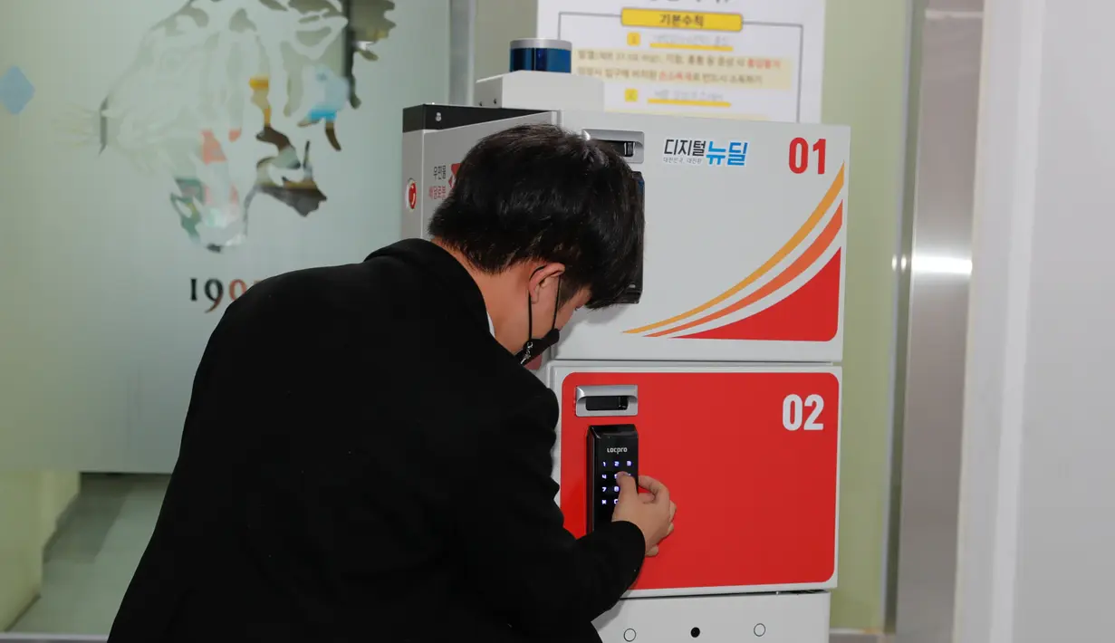 Staf menunjukkan cara kerja robot pengantar di Kampus Sejong Universitas Korea di Kota Sejong, Korea Selatan, 28 Oktober 2020. Kampus itu mengadakan acara untuk mendemonstrasikan layanan pengiriman pos dan surat nirawak menggunakan robot otomatis dan kendaraan nirawak. (Xinhua/Wang Jingqiang)