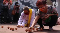 Warga keturunan Tionghoa mencoba mendirikan telur saat perayaan Peh Cun di Khongcu Bio Litang di Pasar Lama, Kota Tangerang, Kamis (25/6/2020). Prosesi yang digelar setiap tanggal 5 bulan 5 penanggalan Tionghoa itu menjadi ungkapan syukur atas segala rezeki dari Tuhan. (Liputan6.com/Angga Yuniar)