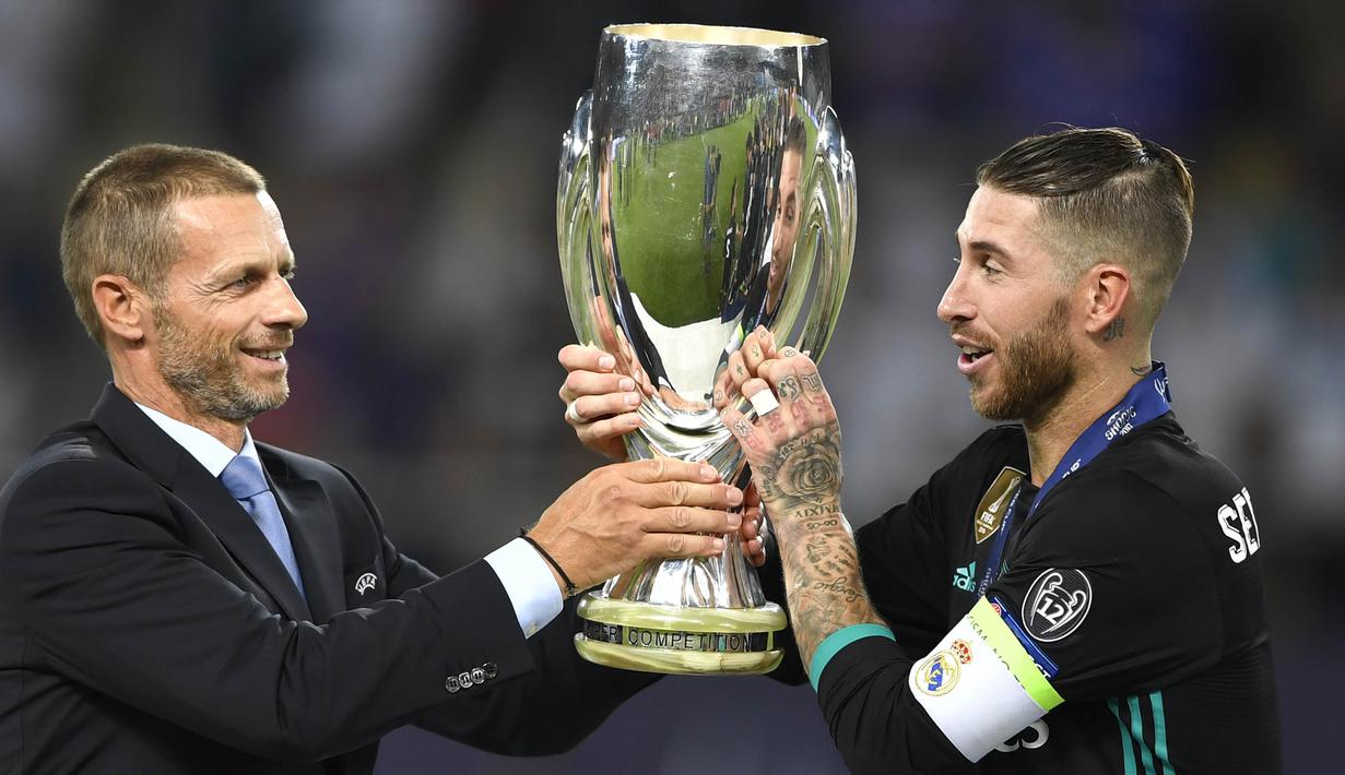 Kapten Real Madrid, Sergio Ramos, menerima trofi Piala Super Eropa usai mengalahkan Manchester United di Stadion Philip II, Skopje, Selasa (8/8/2017). Ini merupakan gelar Piala Super Eropa keempat bagi Real Madrid. (AFP/Dimitar Dilkoff)