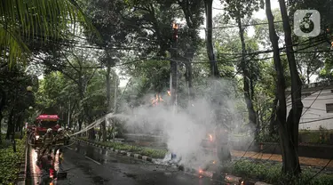 Petugas pemadam kebakaran berusaha memadamkan api yang menyala di salah satu tiang listrik yang ada di jalan Jalan Prof M Yamin menuju Taman Menteng, Jakarta, Rabu (17/1/2024). (Liputan6.com/Faizal Fanani)