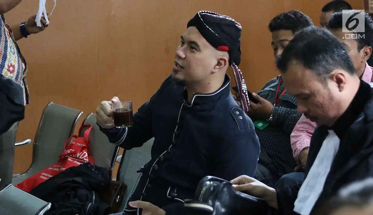 Terdakwa kasus ujaran kebencian, Ahmad Dhani memegang gelas berisi kopi sebelum sidang di PN Jakarta Selatan, Senin (2/7). Sidang tersebut menghadirkan saksi dari jaksa dan saksi meringankan dari Ahmad Dhani. (Liputan6.com/Immanuel Antonius)