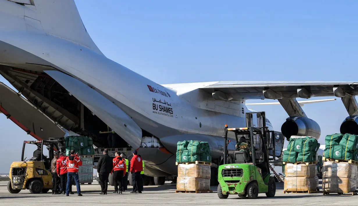 Sejumlah paket bantuan kemanusiaan yang disediakan oleh Arab Saudi untuk para korban gempa bumi Turki dan Suriah diturunkan dari pesawat angkut Ilyushin Il-76TD di Bandara Internasional Aleppo, Suriah Utara, Selasa (14/2/2023). Sepekan pasca-gempa, jumlah korban jiwa merangkak naik hingga di atas 33 ribu orang dan diperkirakan akan terus bertambah. (AFP)
