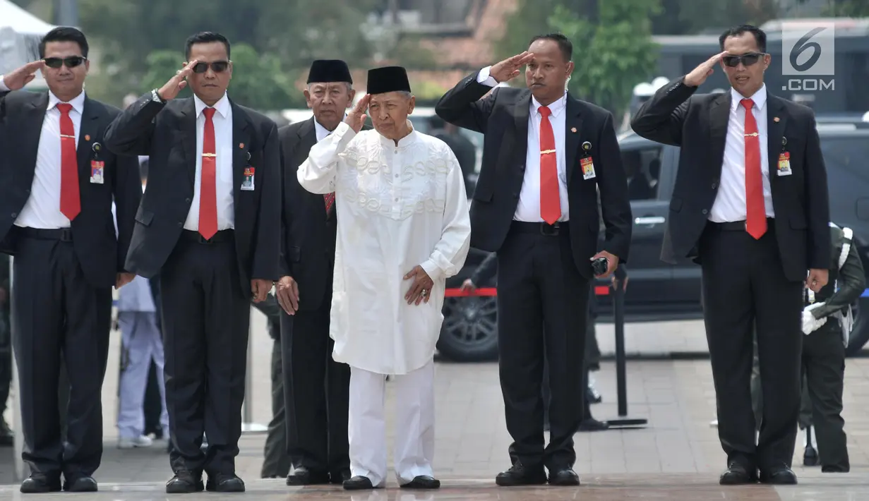 Wakil Presiden ke-9 RI Hamzah Haz (tengah) memberi hormat saat menghadiri pemakaman Presiden ke-3 RI BJ Habibie di TMP Kalibata, Jakarta, Kamis (12/9/2019). Habibie dikebumikan di sebelah makam istri tercinta, Ainun Aini. (merdeka.com/Iqbal Nugroho)