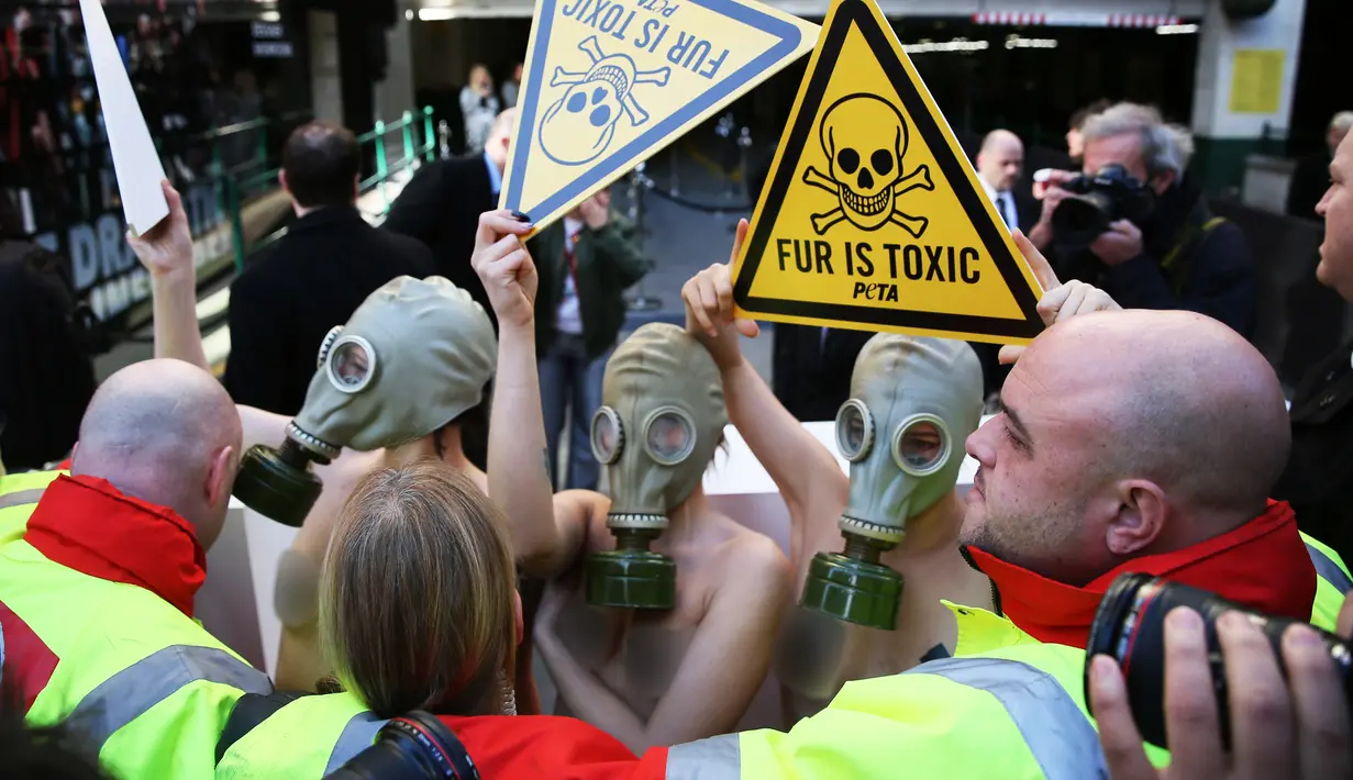 Sejumlah demonstran menggunakan masker gas saat unjuk rasa menolak London Fashion Week, Inggris (19/2). Para wanita ini bertelanjang saat melakukan aksi demo. (REUTERS / Neil Balai)
