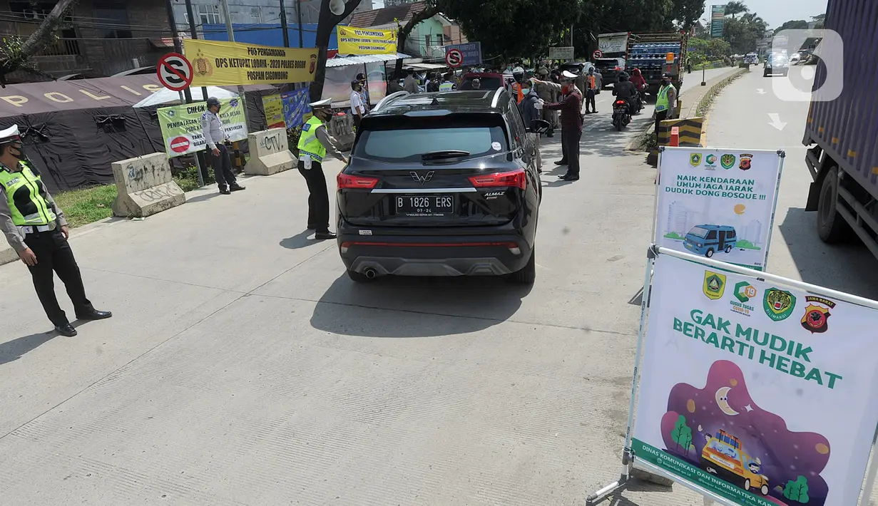 Polantas Polres Bogor mengatur lalu lintas yang melintasi Pos Pengawasan Larangan Mudik di Cigombong, Bogor, Rabu (29/4/2020). Polres Bogor terus melakukan penyekatan  mencegat pemudik sekaligus PSBB mengantsipasi penyebaran virus Covid-19. (merdeka.com/Arie Basuki)