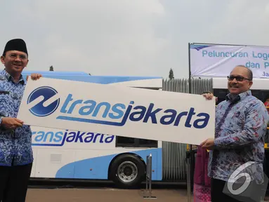 Plt Gubernur DKI Jakarta Basuki Tjahaja Purnama (Ahok) memegang logo baru Transjakarta, Jakarta, Senin (10/11/2014) (Liputan6.com/Herman Zakaria)