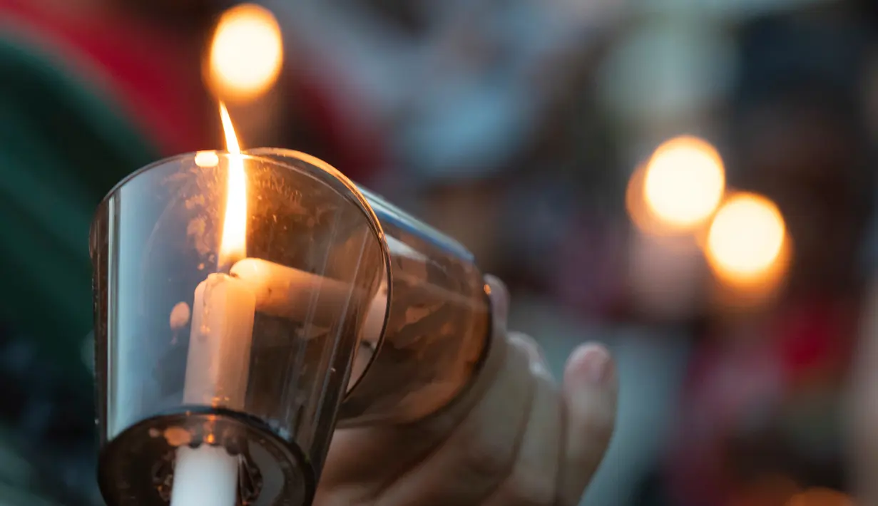 Lilin dinyalakan untuk mengenang korban penembakan di sekolah Santa Fe, Texas, Amerika serikat, Jumat (18/5). Pelaku menembak menembaki teman sekelasnya dengan senapan dan pistol. (Stuart Villanueva/The Galveston County Daily News via AP)