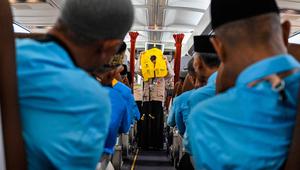Para calon jemaah haji Indonesia menyimak cara menggunakan jaket penyelamat dari awak kabin di dalam pesawat Boeing 717 yang sudah tidak digunakan lagi selama sesi pelatihan keselamatan pra-keberangkatan di pusat embarkasi haji Banda Aceh pada Kamis 14 Mei 2026. (CHAIDEER MAHYUDDIN/AFP)
