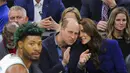 Pangeran Inggris William dan Kate Middleton, Putri Wales bersama Mantan pemain dan pelatih Celtics Tom "Satch" Sanders (kiri) menyaksikan pertandingan NBA antara Boston Celtics dan Miami Heat di TD Garden di pusat kota Boston, pada 30 November 2022. (Photo by Brian Snyder/Pool/AFP)