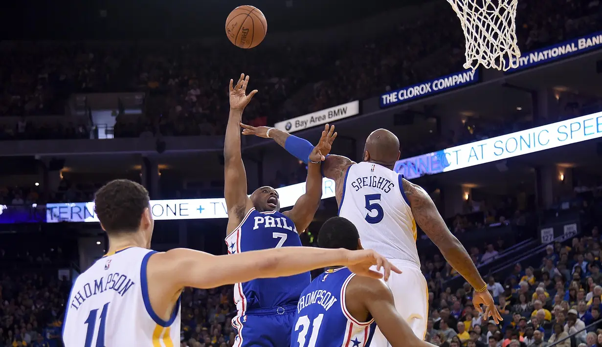 Pemain Philadelphia 76ers, Carl Landry  gagal memasukan bola setelah diblok pemain Warriors Marreese Speights #5 pada lanjutan NBA di Oracle Arena, Minggu (27/3/2016). Warriors menang atas 76ers 117-105. (Thearon W. Henderson/Getty Images/AFP)
