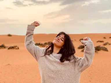 Camila Cabello tampak berpose hanya menggunakan sweater di sebuah padang pasir di negeri Arab. Gadis berusia 22 tahun ini tampak sangat bahagia dengan senyum yang mengembang dan kedua tangan diangkat ke atas. (Liputan6.com/IG/@camila_cabello)