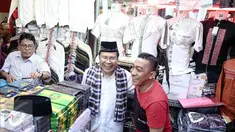 Mantan Menko Maritim,  Rizal Ramli melihat baju-baju saat berkunjung ke Blok A, Pasar Tanah Abang, Jakarta, Sabtu (13/8). Kunjungannya tersebut terkait pencalonannya sebagai cagub pada Pilkada DKI Jakarta 2017.(Liputan6.com/Faizal Fanani)