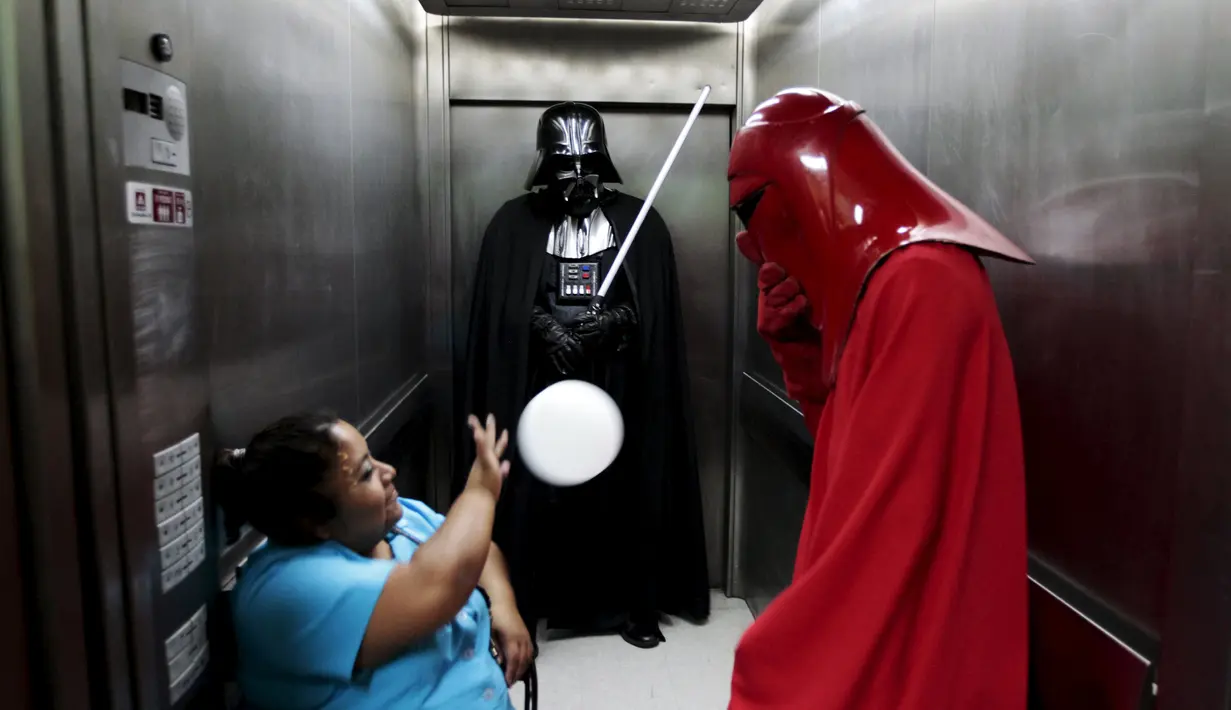 Sejumlah orang berpakaian karakter Star Wars berbincang dengan operator lift selama acara amal oleh El Salvador Star Wars fan club di Rumah Sakit Benjamin Bloom Anak Nasional di San Salvador, El Salvador (14/12). (REUTERS/Jose Cabezas)